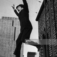 A man in a suit and hat attempts to commit suicide by jumping from a fire escape, circa 1935. (Photo by Lass/Hulton Archive/Getty Images)